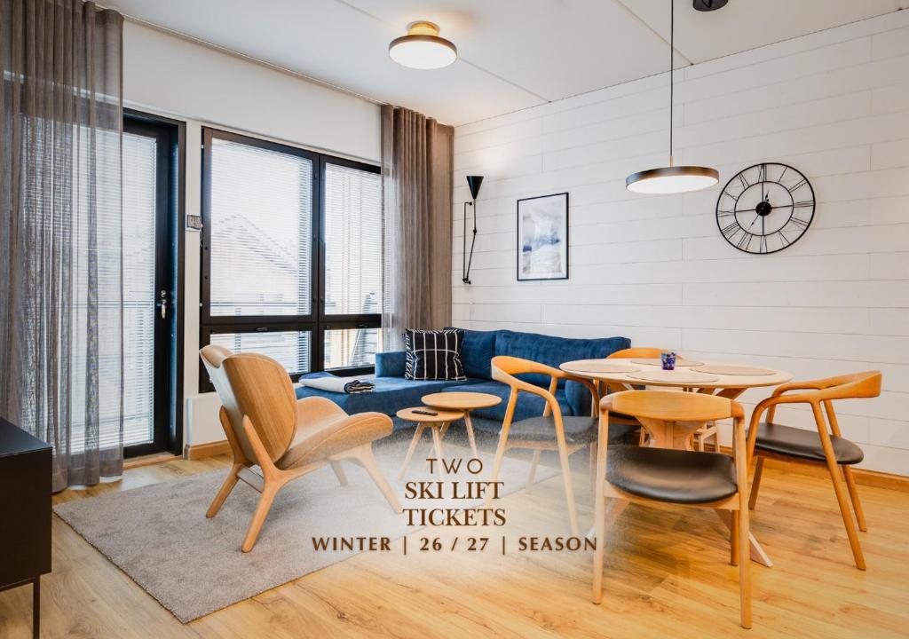 a living room with a blue couch and a table and chairs at Cranberry C11 Levi Center incl 2 ski passes by Aavalevi in Levi
