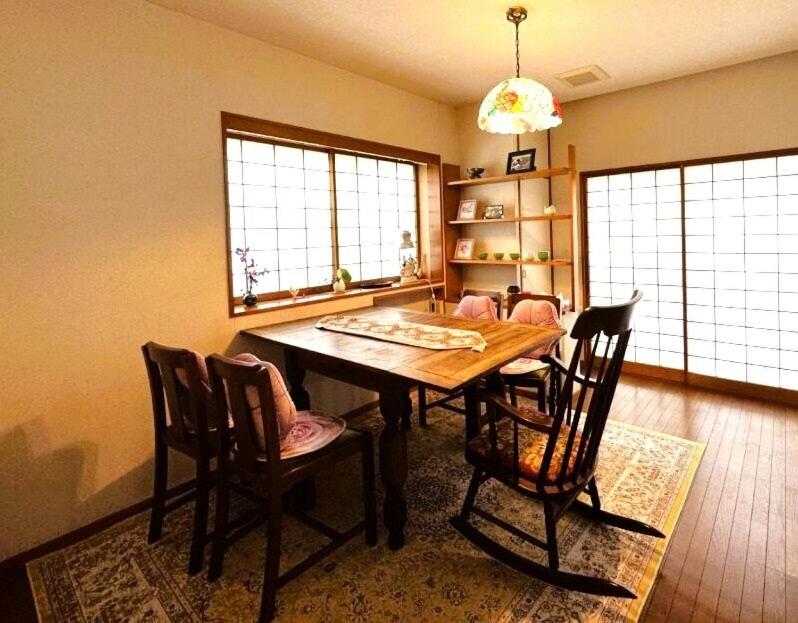 a dining room with a wooden table and chairs at 伊東旅館 禅- Zen - in Ito