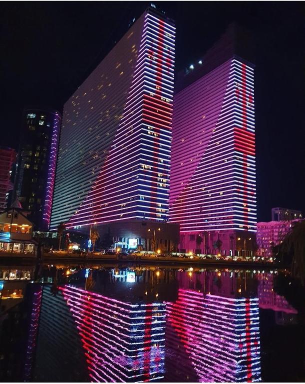 a large building lit up with red and purple lights at Orbi City D2 - Luxury Hotel - Sea View in Batumi