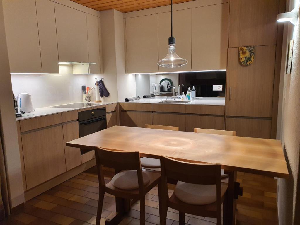 a kitchen with a wooden table and chairs at Triangel C Kiefer in Parpan