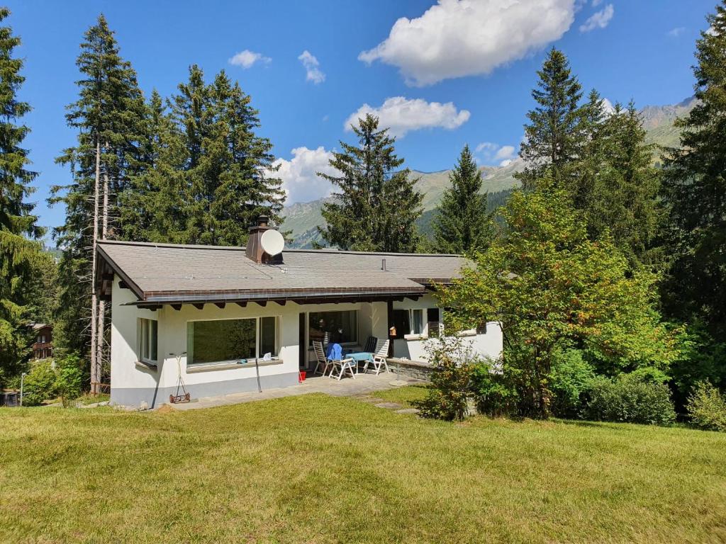 a small white house in the middle of a field at Ferienhaus Tina in Lenzerheide
