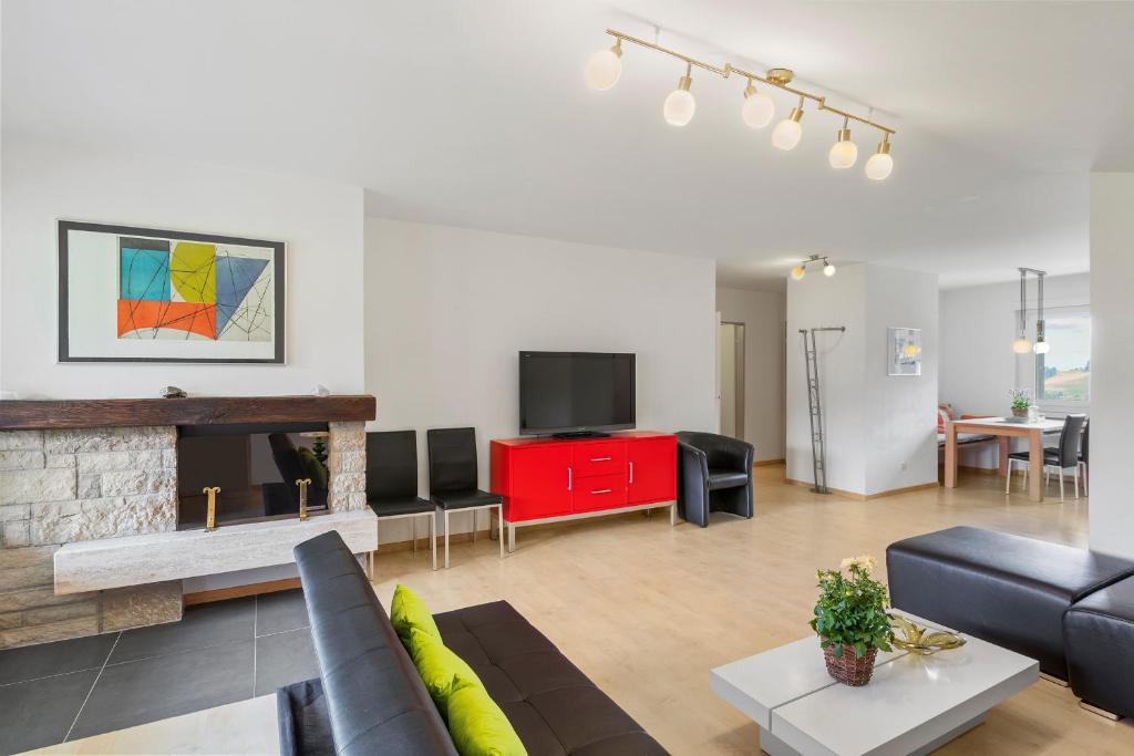 a living room with a couch and a tv at Triangel B Rezia in Parpan