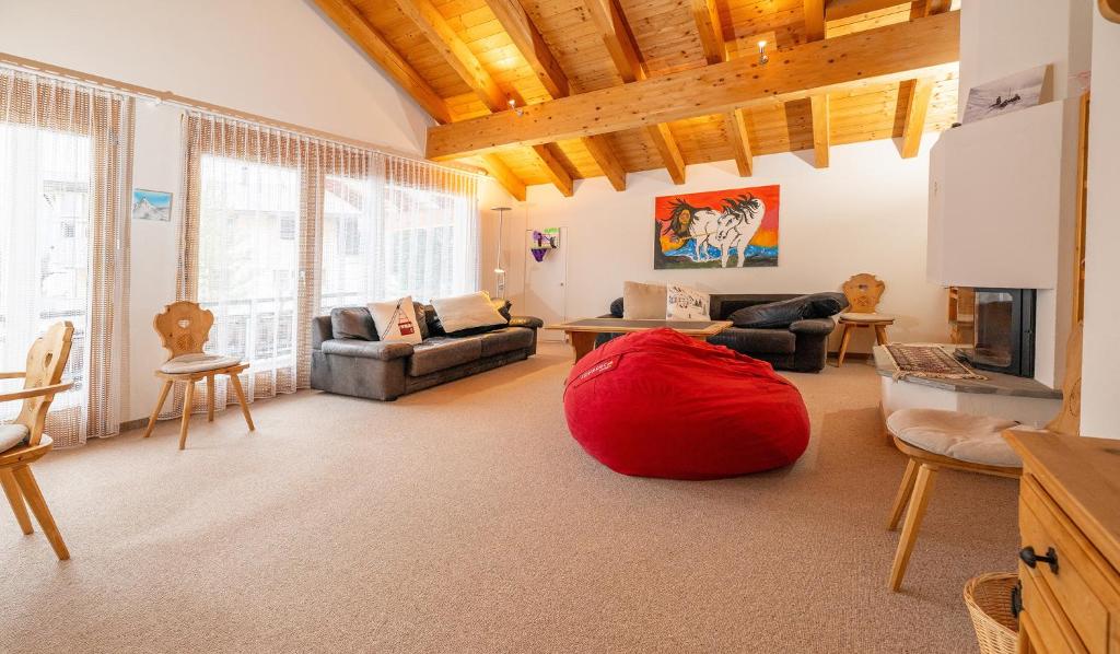 a living room with a red bean bag on the floor at Clois B Loughlin in Lenzerheide