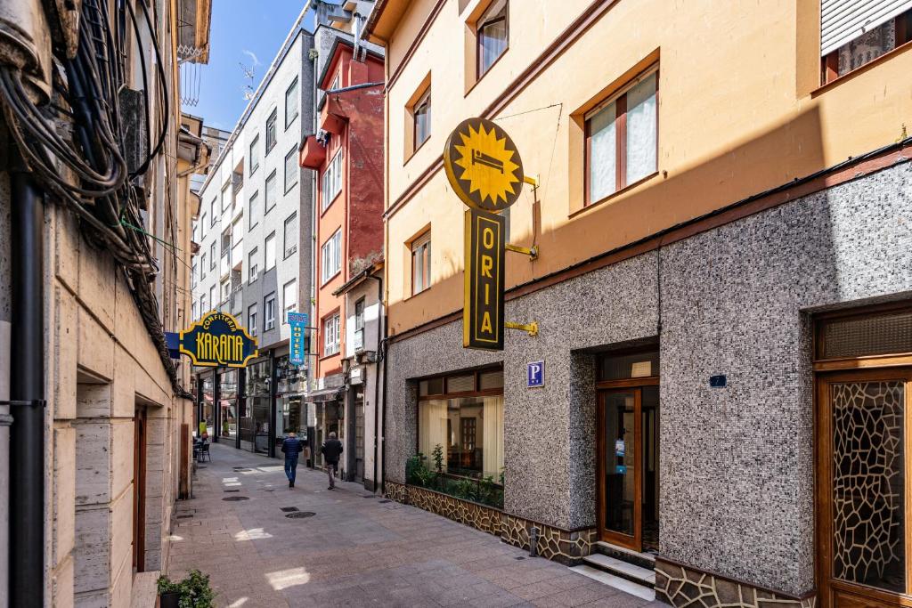 a clock on the side of a building on a street at Hostal Oria in Luarca