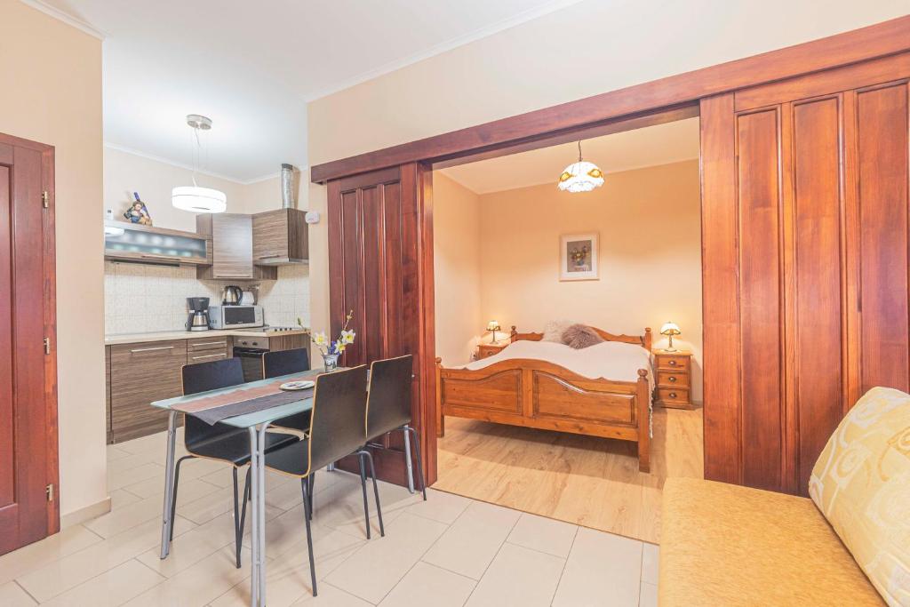 a kitchen and a dining room with a bed at Besenyei Apartman in Sárvár
