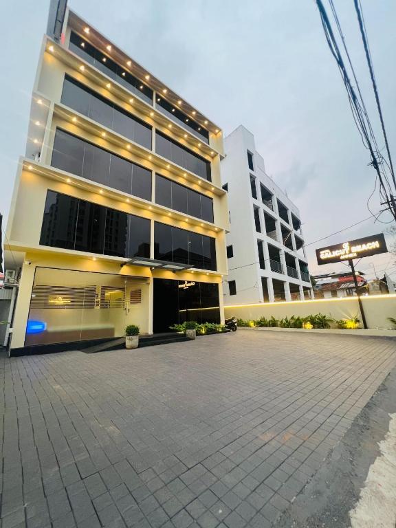 a large building with a parking lot in front of it at Hotel Calicut Beach-Silk Street in Kozhikode