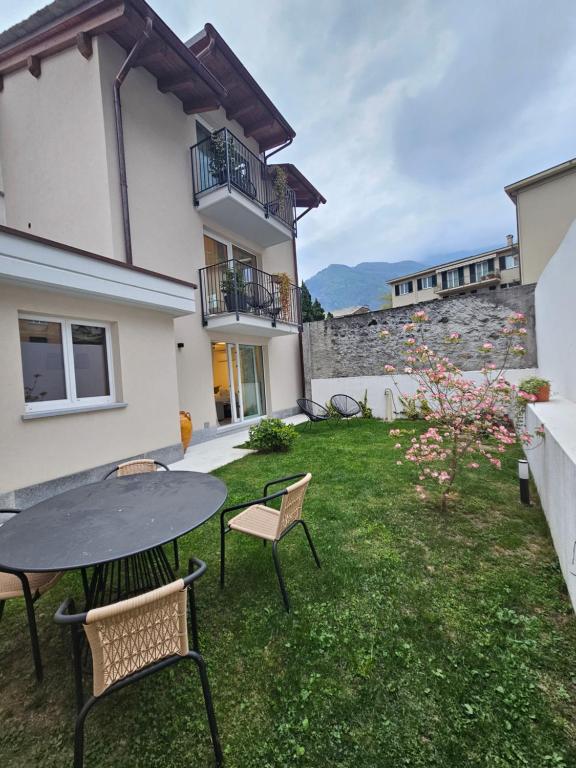 a patio with a table and chairs in a yard at La Cereria INES in Chiavenna