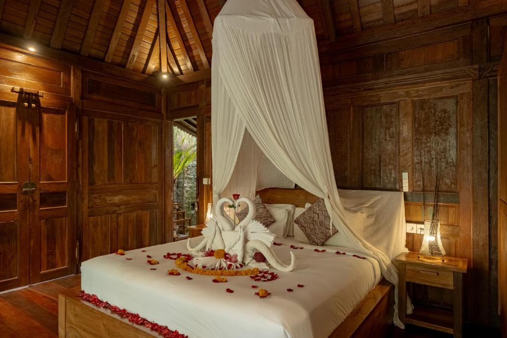 two people sitting on a bed in a room at Bumbung Sari Villa in Ubud