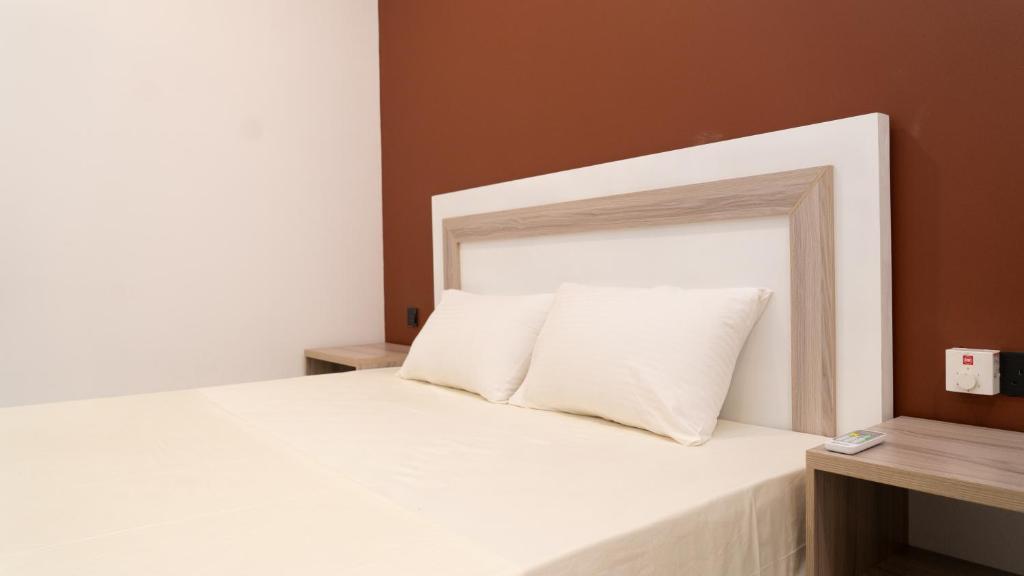 a white bed with a white headboard in a room at A One Resort in Negombo