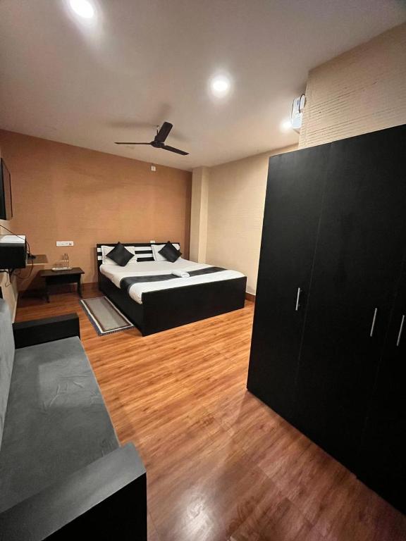 a bedroom with a bed and a wooden floor at Meeraj Residency in Mātigara