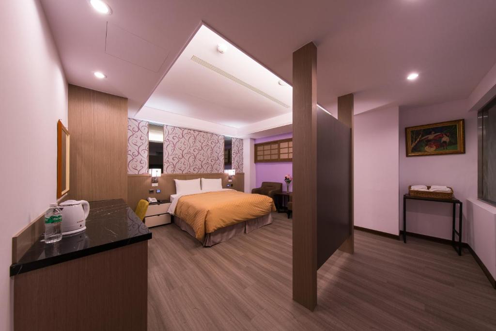 a hotel room with a bed and a desk at Sir Motel - Sanchong in Taipei