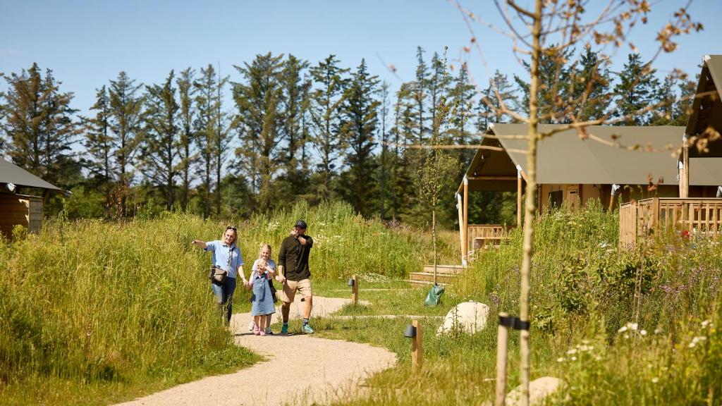 a family walking down a path in a field at Fårup Skovbrynet in Saltum