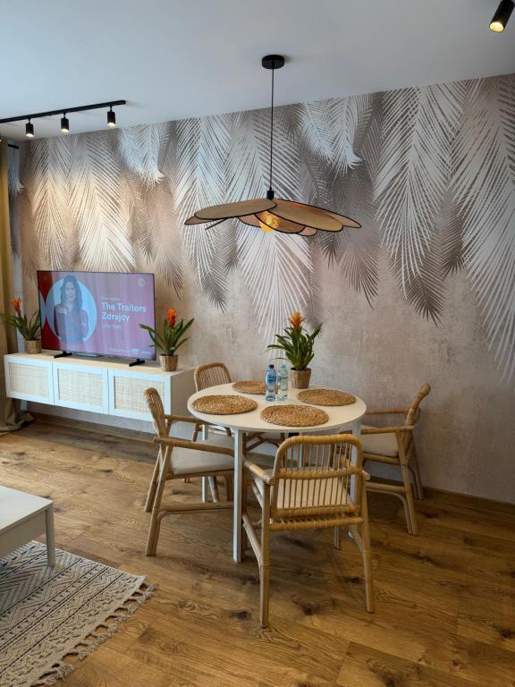 a dining room with a table and chairs and a tv at Apartament Londyn in Pniewy
