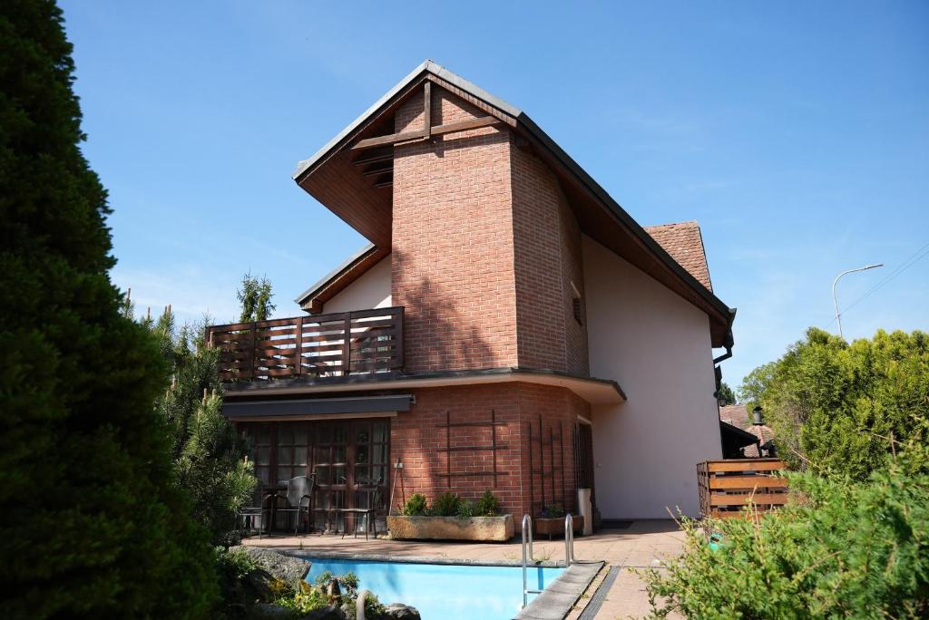 a house with a swimming pool in front of it at Rodinný Penzion U Nouzů in Staré Hradiště