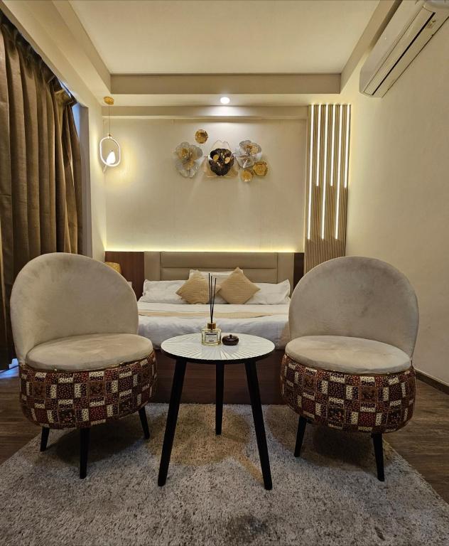 a room with two chairs and a bed and a table at The Kaksh in Greater Noida