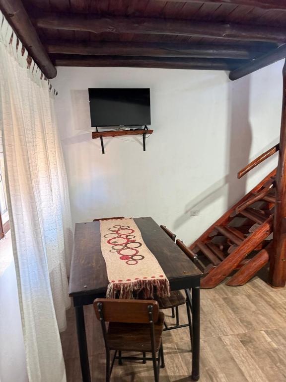 a table with chairs and a television on a wall at Dulce Claudina 3 in Mercedes