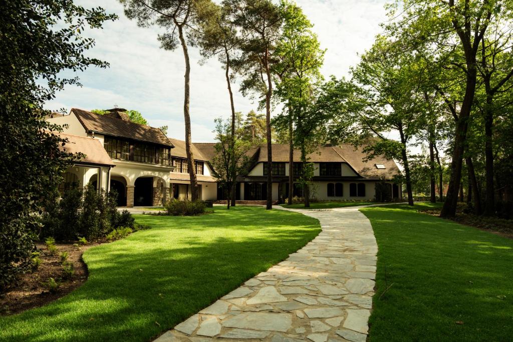 a house with a green lawn and a walkway at Corsendonk Hooge Heyde in Lichtaart