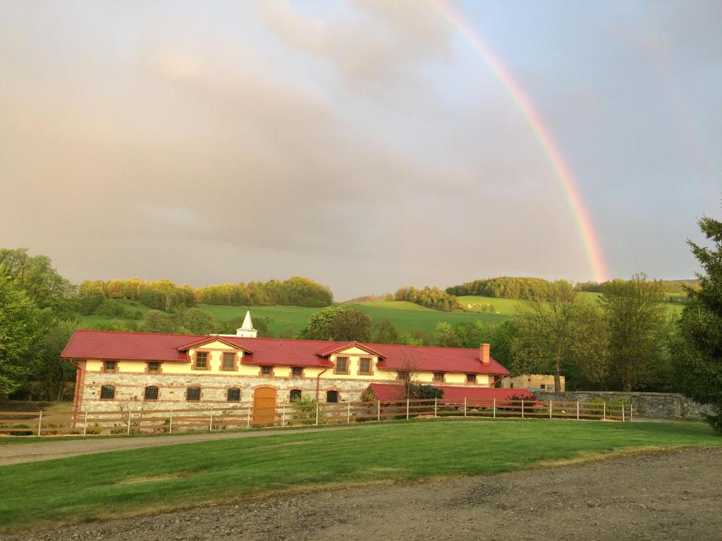 a rainbow over a barn with a house at Ranc pod Rejvizem in Zlaté Hory