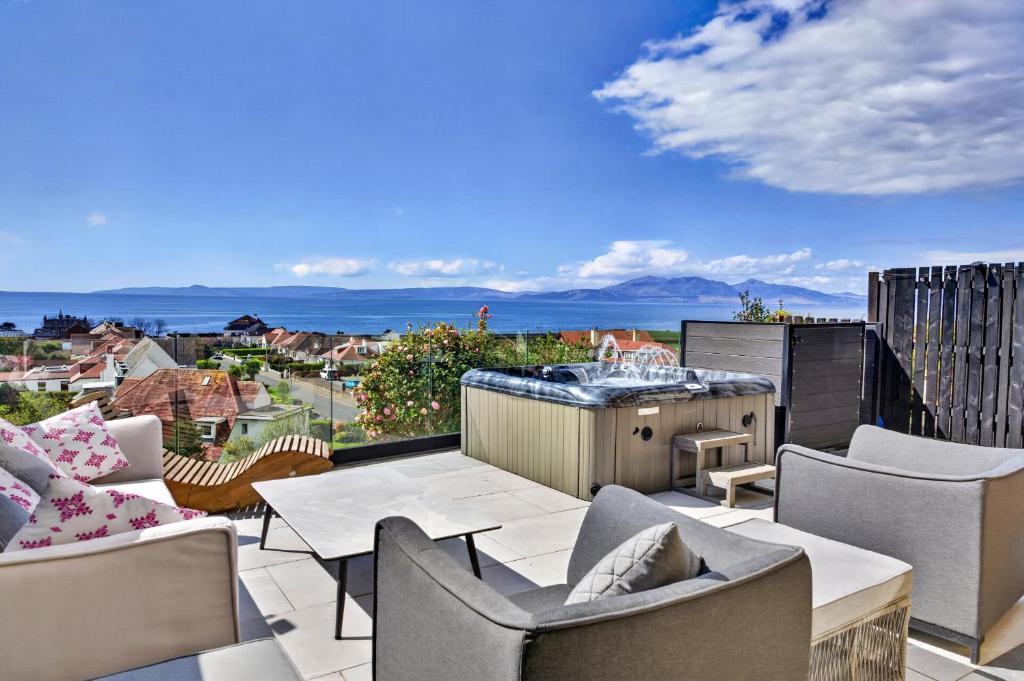 a patio with chairs and a table and a kitchen at Finest Retreats - Seamill Beach House in Seamill