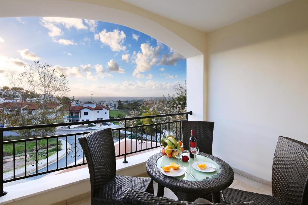 una mesa y sillas en un balcón con vistas en Chloraka Terrace Apartments, en Pafos