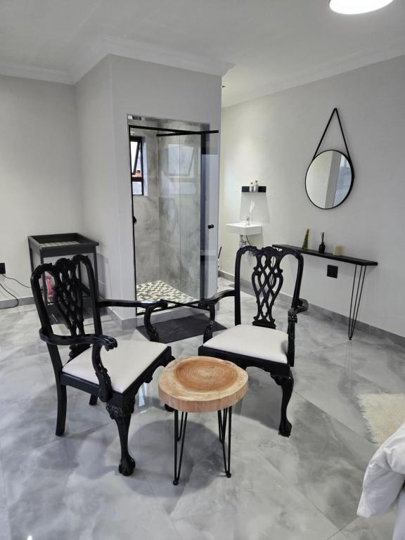 a room with two chairs and a table and a mirror at Cjabaledi Private Guesthouse in Centurion