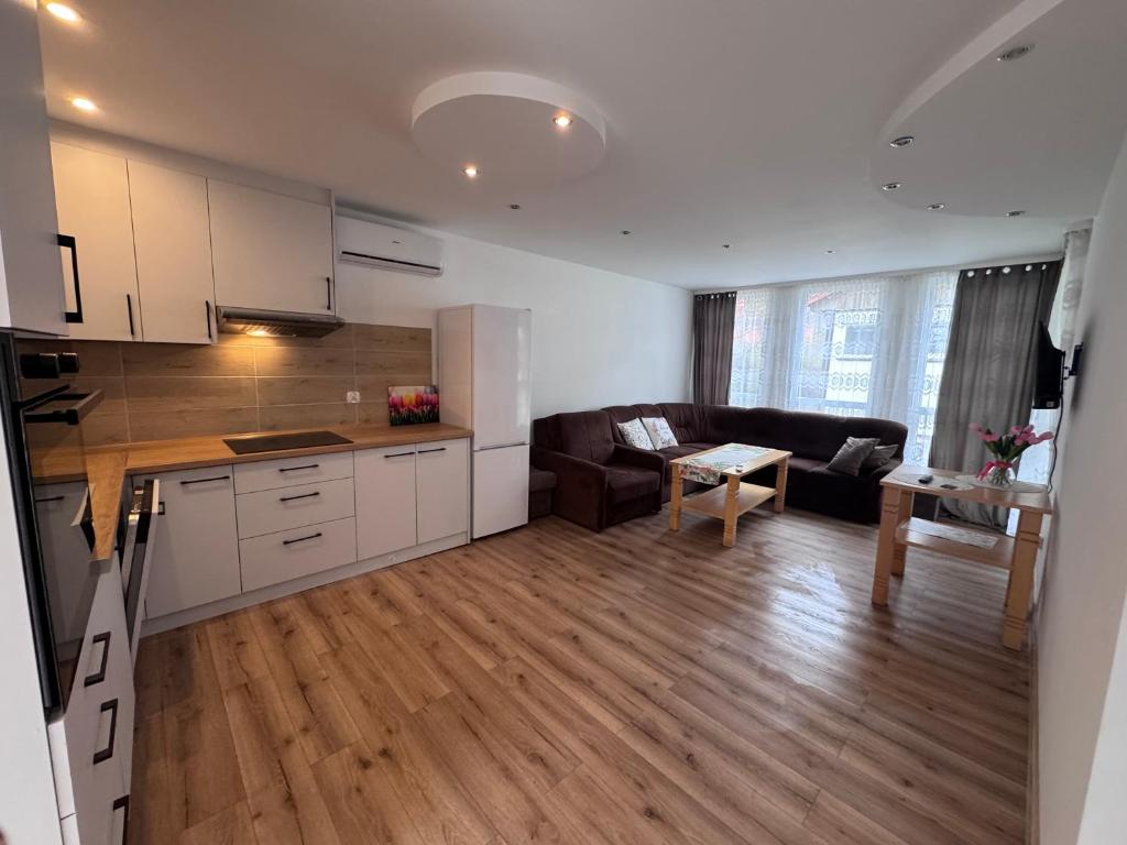a kitchen and living room with a couch and a table at Domek Premium in Tleń
