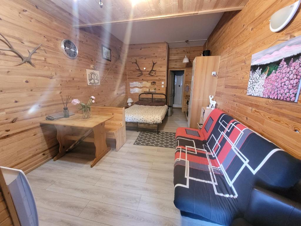 a room with wooden walls and a couch and a table at Appartement Pyrénées 2000 in Bolquere Pyrenees 2000