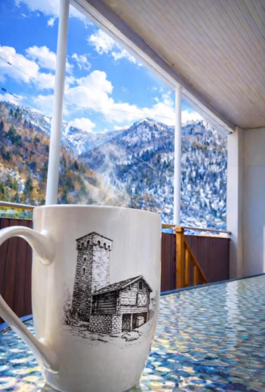 a coffee cup with a drawing of a house on it at Hotel Dede in Lentekhi