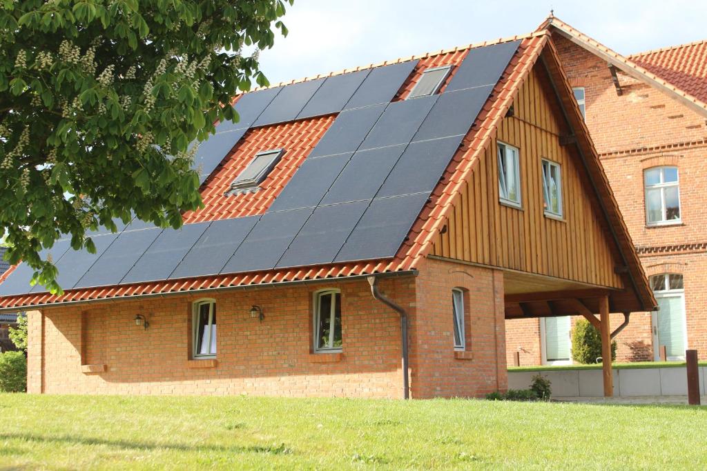 a house with solar panels on its roof at Sternennächte auf einem echtem Bauernhof in Warpke
