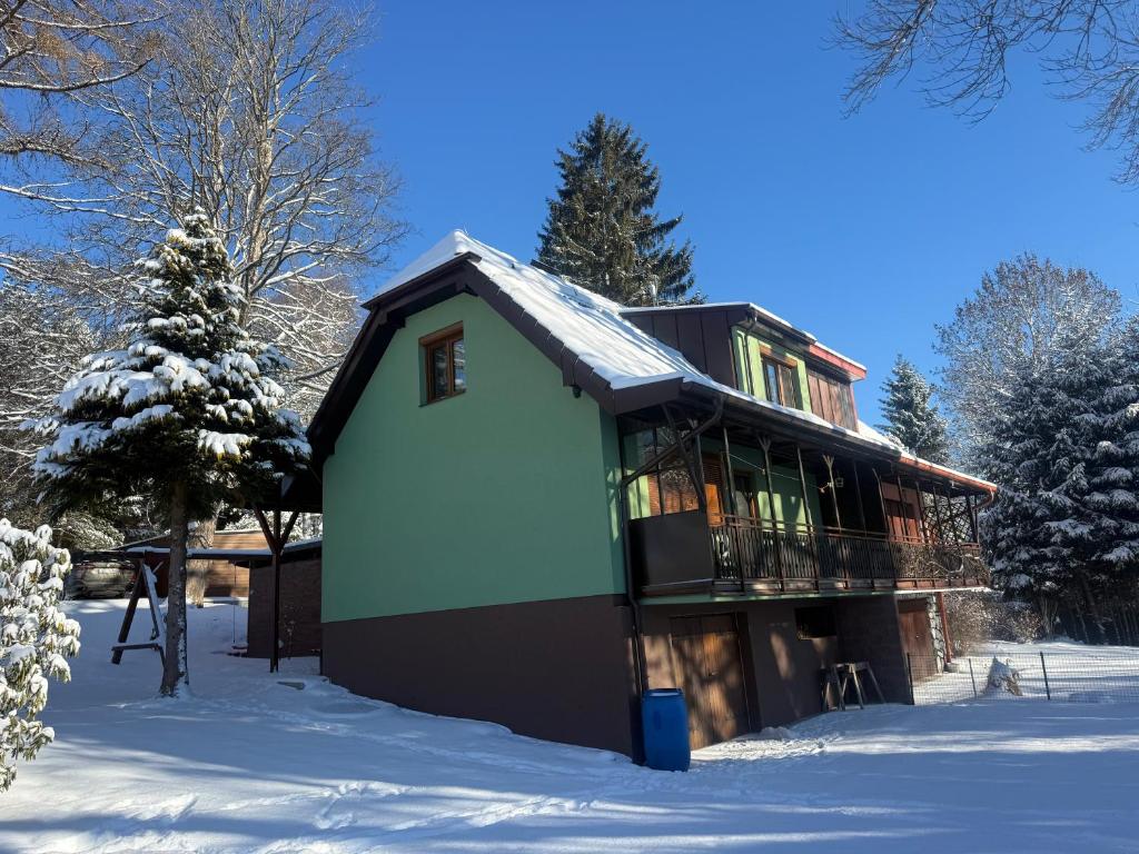 a house in the snow with snow at Chata pod javorem in Frymburk