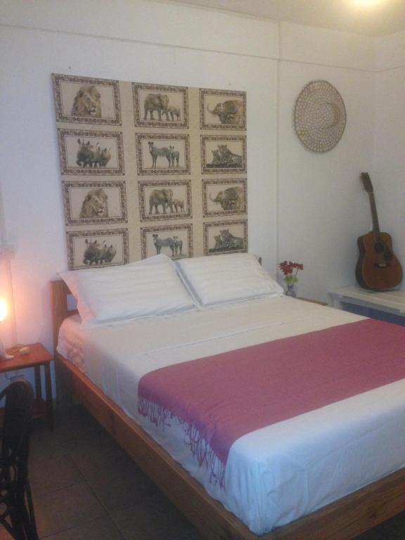 a bedroom with a bed with a guitar on the wall at Habitation Joseph in Trou dʼ Eau Douce