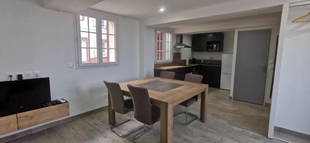 a kitchen and dining room with a wooden table and chairs at Jauxvial 1 in Jaux