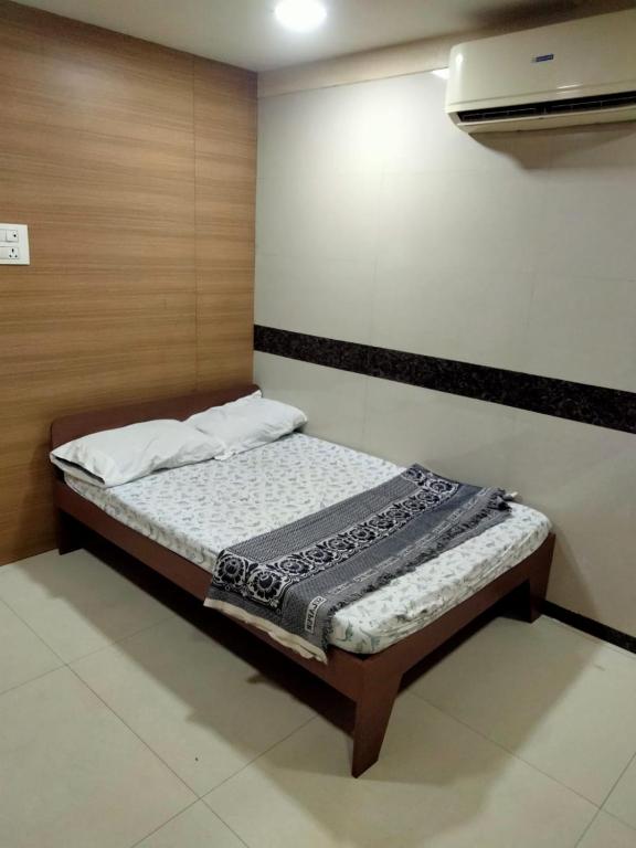 a small bedroom with a bed in a room at Balaji rooms&domentry in Surat
