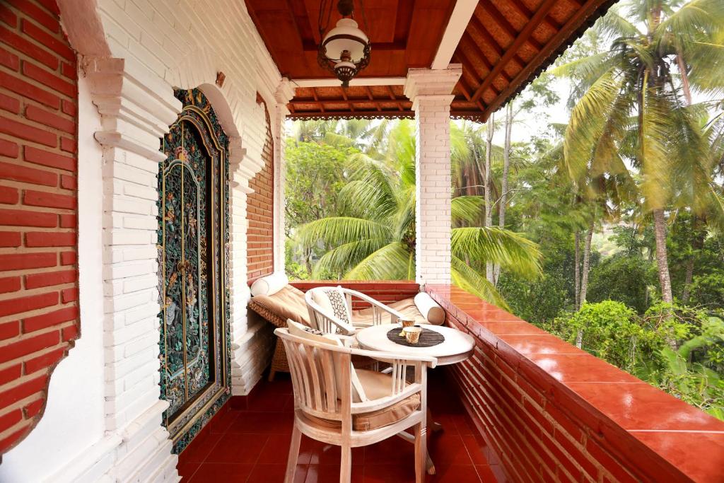 un porche con mesa y sillas en Danaya's Cottage and Studio en Ubud