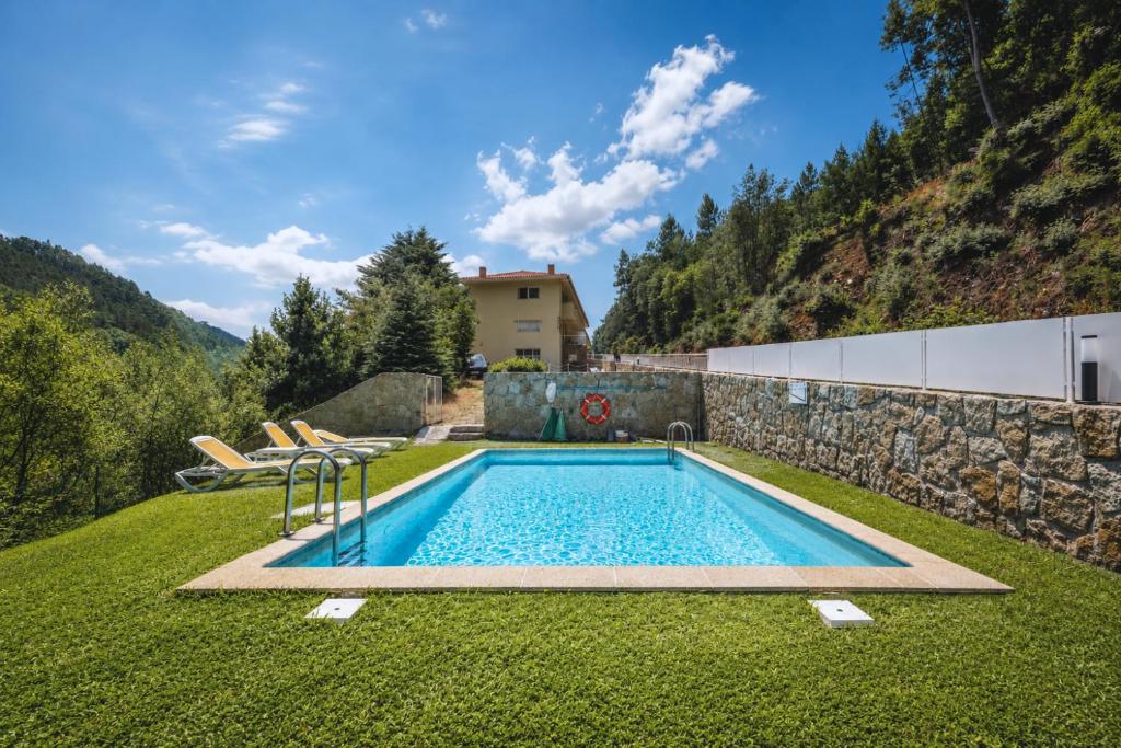a swimming pool in the yard of a house at Aqua Gerês in Geres
