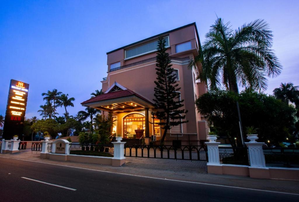 a house with lights on in front of a street at Holiday Hotel in Cherai Beach