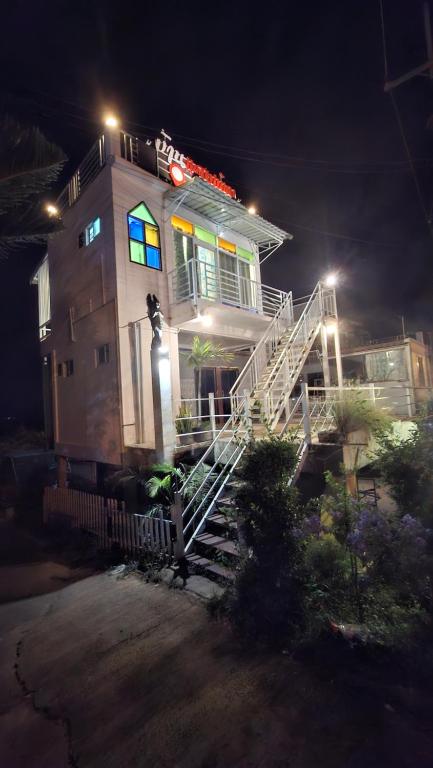 una casa con un camion dei pompieri sul tetto di notte di บ้านแช่มช้อย 360 a Khao Kho