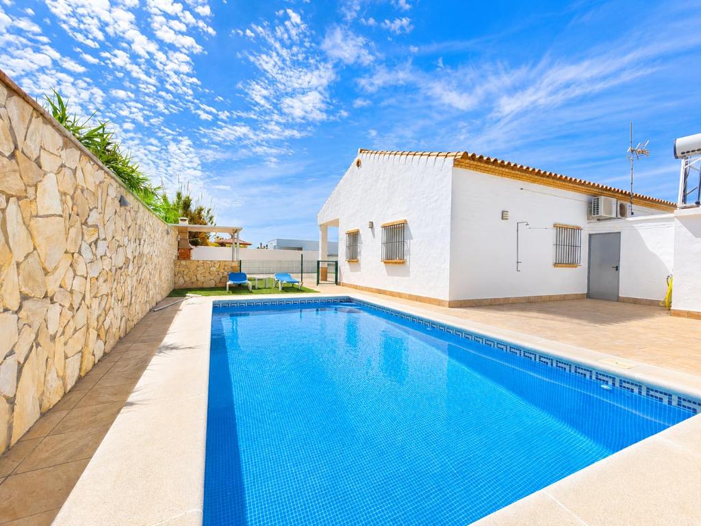 a villa with a swimming pool and a building at Chalet Playa Roche in Roche