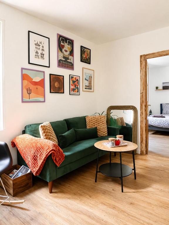 a living room with a green couch and a table at Nid douillet cosy au cœur d'Angers, idéal à deux in Angers