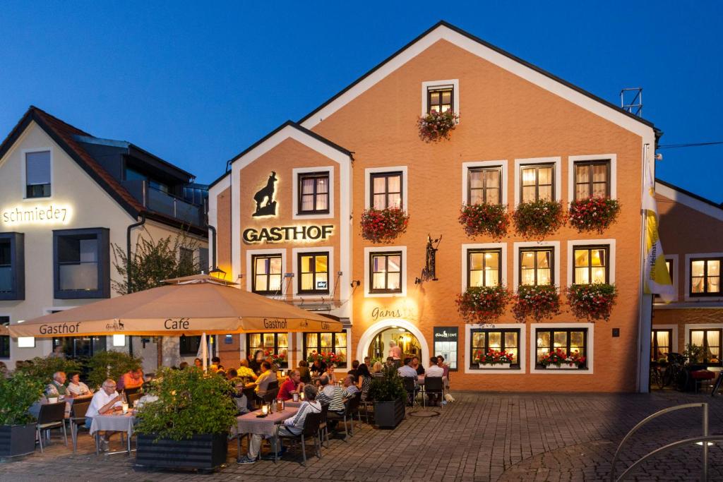 un groupe de personnes assises à des tables devant un bâtiment dans l'établissement Hotel Die Gams, à Beilngries