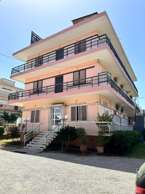 a building with stairs and balconies on it at Hotel TSAPARAS in Alíartos