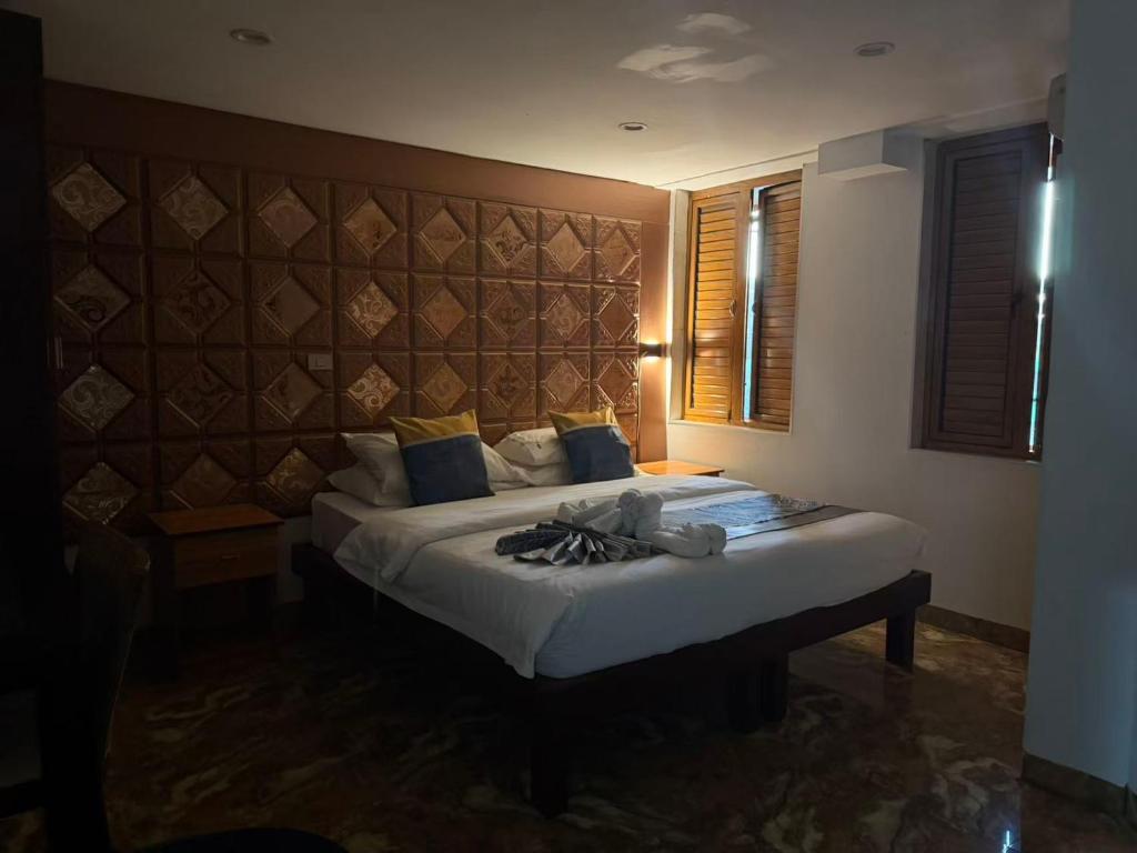 ein Schlafzimmer mit einem großen Bett mit großem Kopfteil in der Unterkunft Cape Town Hotel in Nadi