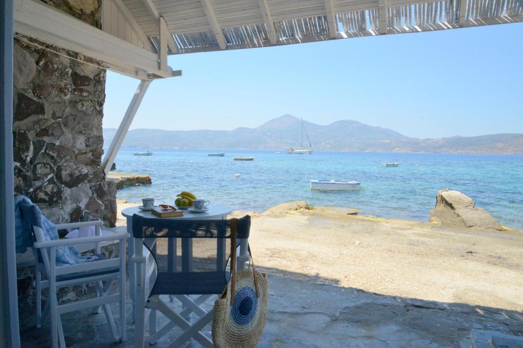 a table and chairs sitting next to the ocean at Seafis Boathouse Klima in Klima