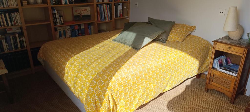 a bedroom with a bed with a yellow blanket at Bouquin-couette in Plouguerneau