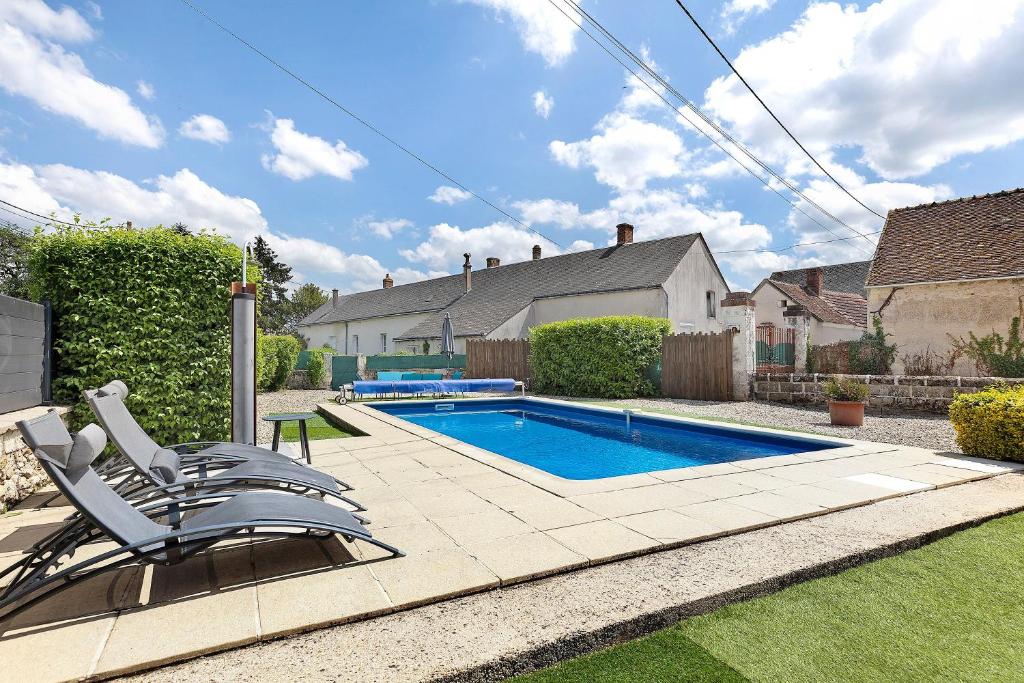 a swimming pool in a yard with two lounge chairs at Le Gîte Des Anges - 4pers, Piscine in Angé