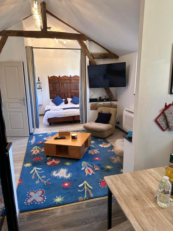 ein Wohnzimmer mit einem blauen Teppich und ein Zimmer mit einer Couch in der Unterkunft Villa Marguerite in Castelnau-Rivière-Basse