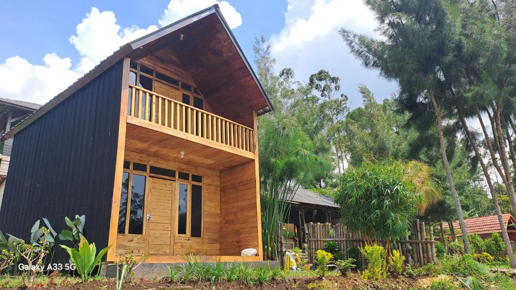a small house with a black roof at Bliss 10 people in Palayangan
