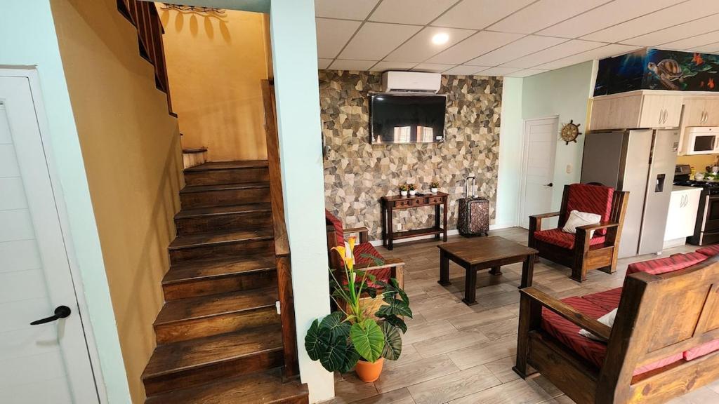 a room with a staircase and a living room with chairs at Villa Patty by the beach in El Conacaste