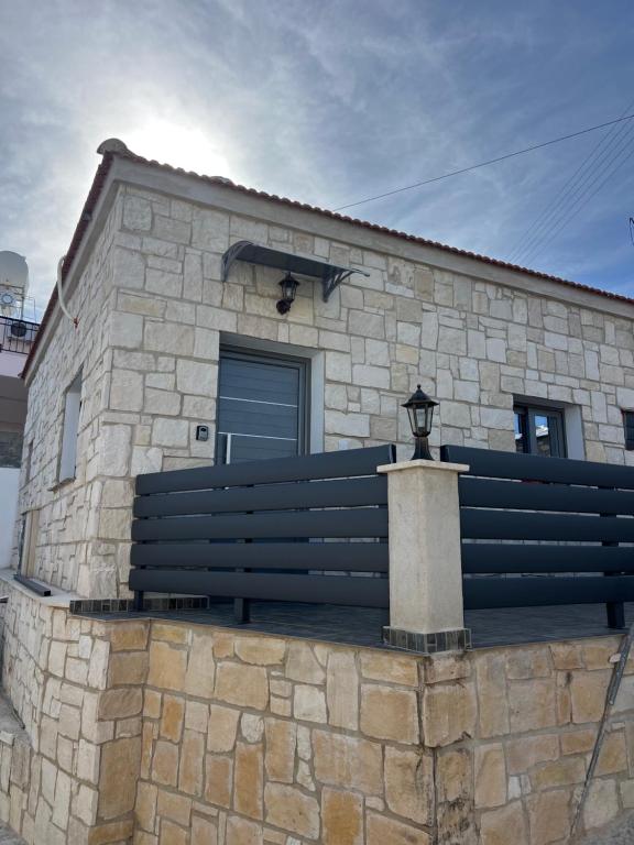 a stone building with a bench on a stone wall at Central Stone Living in Peyia
