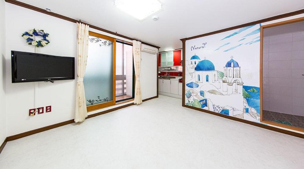 a room with a flat screen tv on a wall at Daecheon jeulgeoun pension in Boryeong